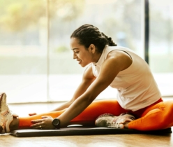 A woman enjoying a yoga stretch indoors, promoting a healthy lifestyle.