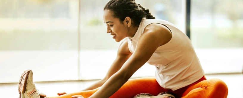A woman enjoying a yoga stretch indoors, promoting a healthy lifestyle.